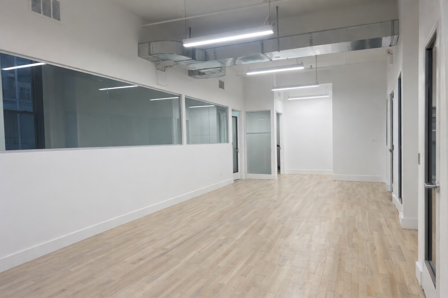 Bright Midtown Office with Exposed Brick and Glass Rooms