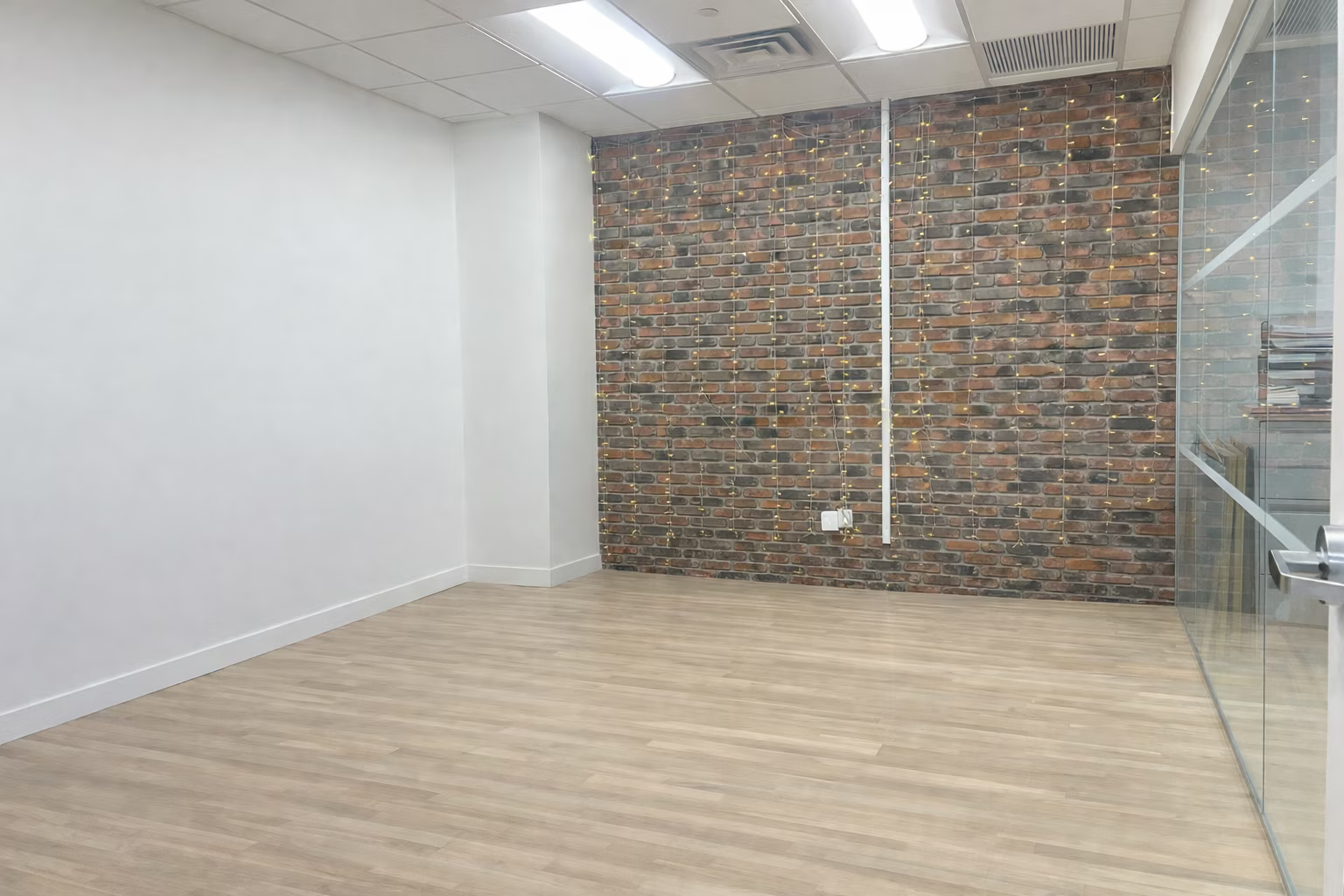 Bright Midtown Office with Exposed Brick and Glass Rooms