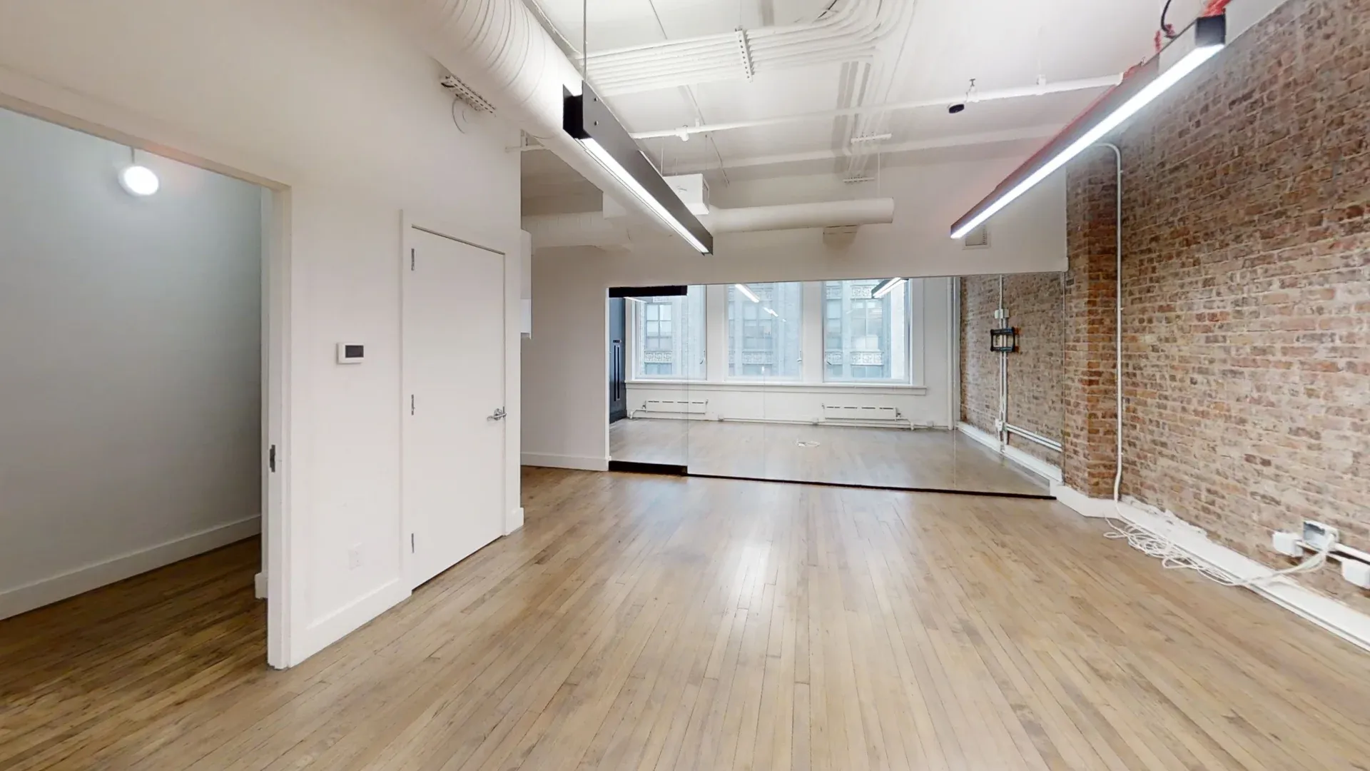 Airy Midtown Office with Exposed Brick and High Ceilings
